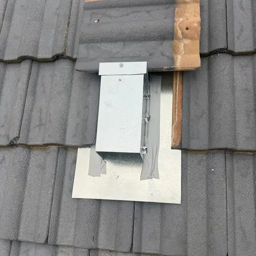 One-way possum door chute fitted on a grey tiled roof